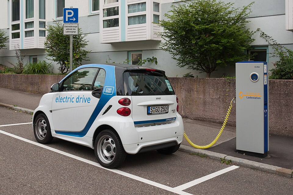 An electric car plugged into a public charging station