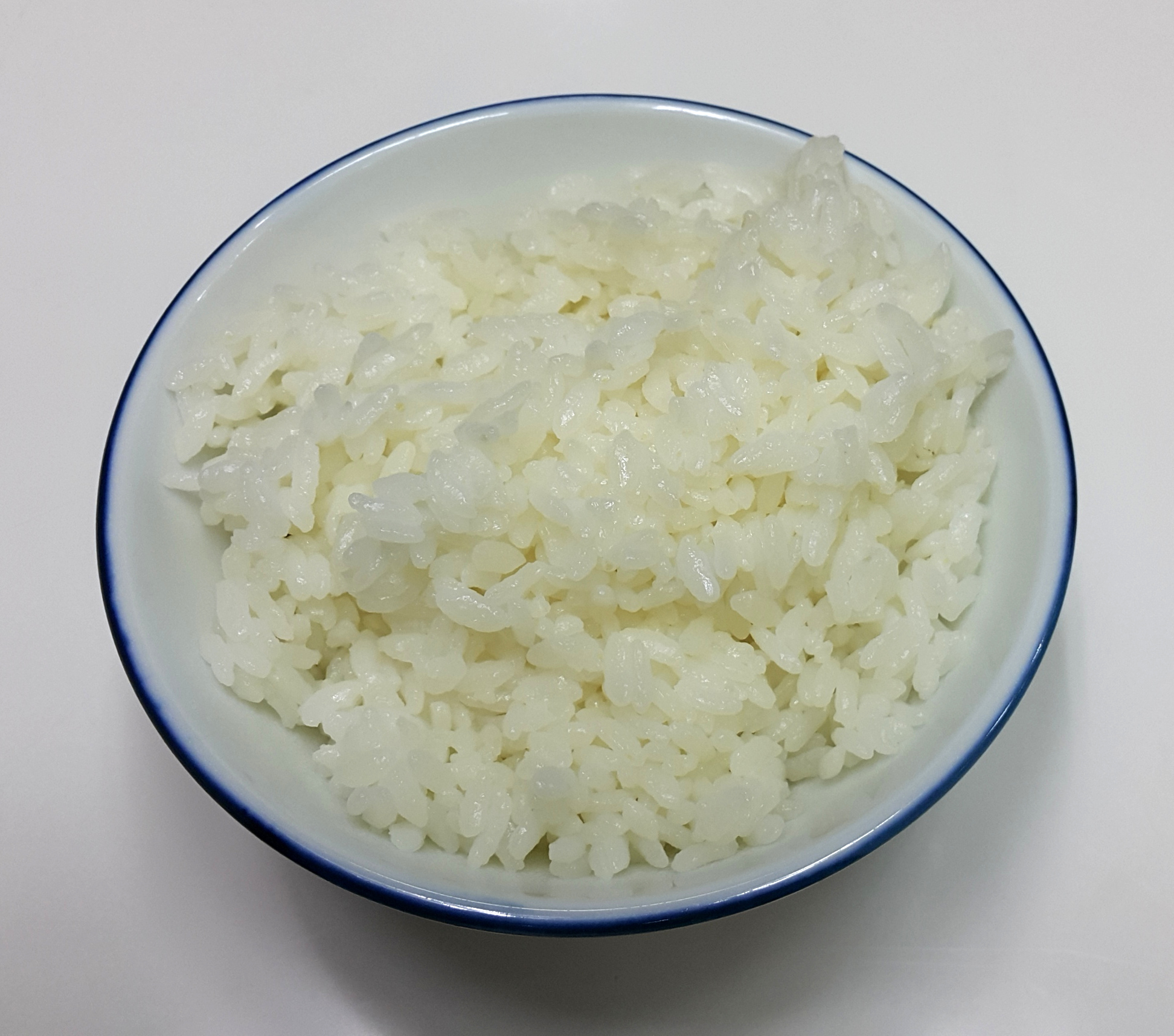 A bowl of cooked white rice on a table